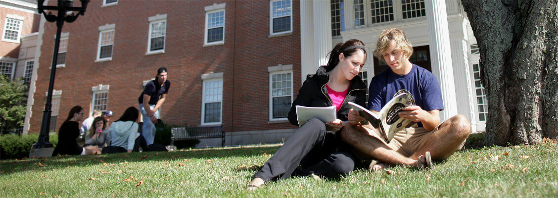 Two groups of students gathered on the lawn in front of a St. Francis Xavier University residence building