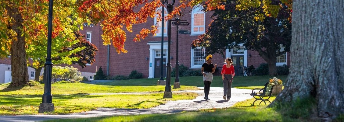 Two female, black students walk through the Acadia University campus in autumn.
